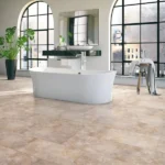Bathroom with a white bathtub and beige stone-look vinyl flooring