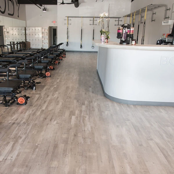 Light gray wood-look vinyl flooring in fitness studio